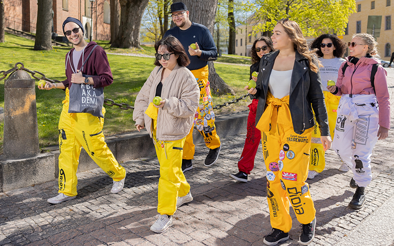 A group of students walking with apples in their hands.