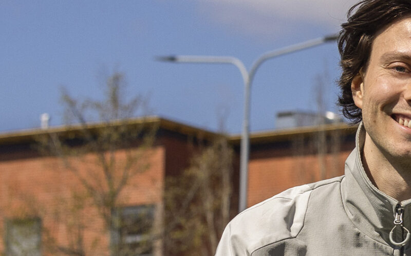 Iloisesti hymyilevä opiskelijahahmo.