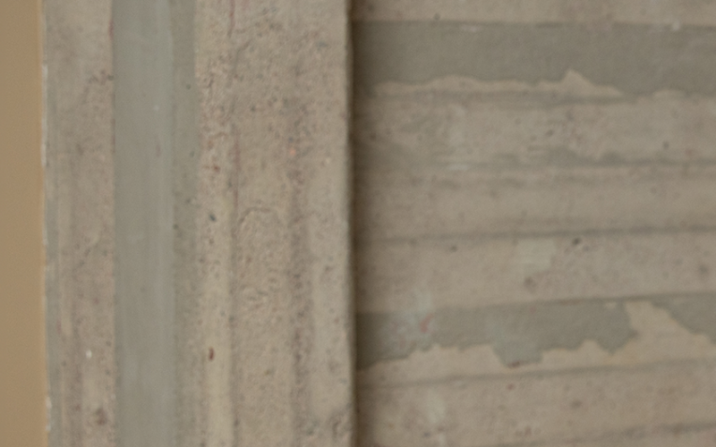 Studeranden lutar sig mot ett bord med mobilen i handen och tittar in i kameran.