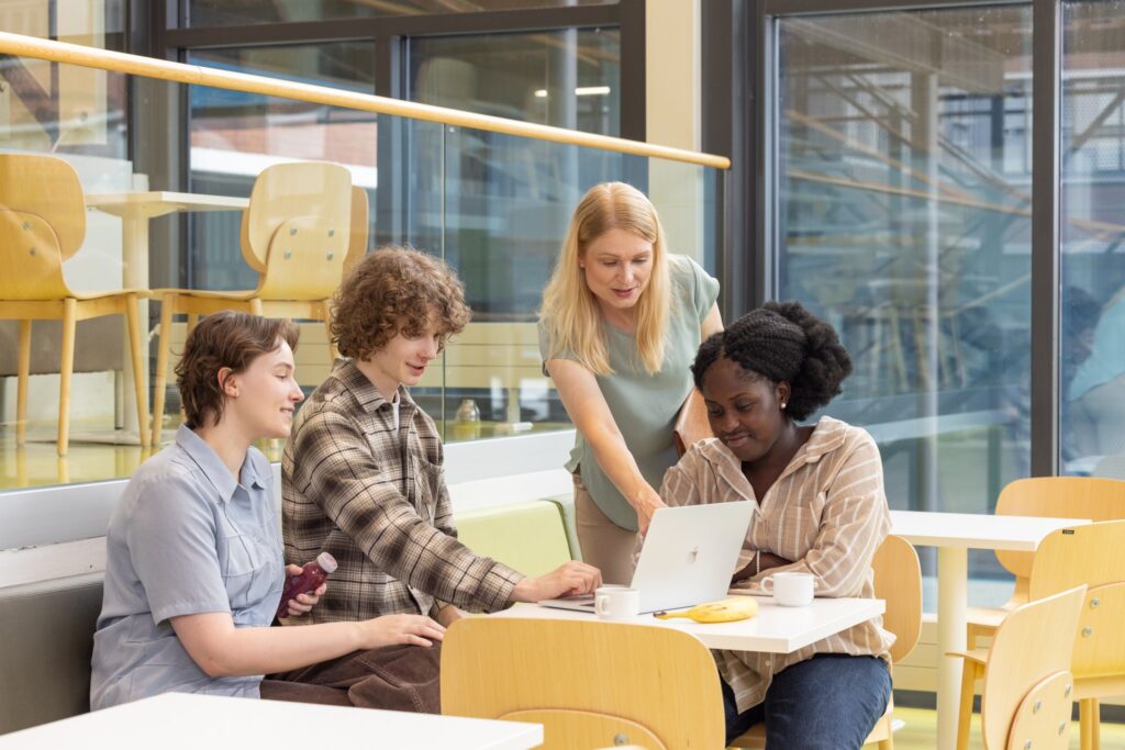 4 people looking at a computer in a study area